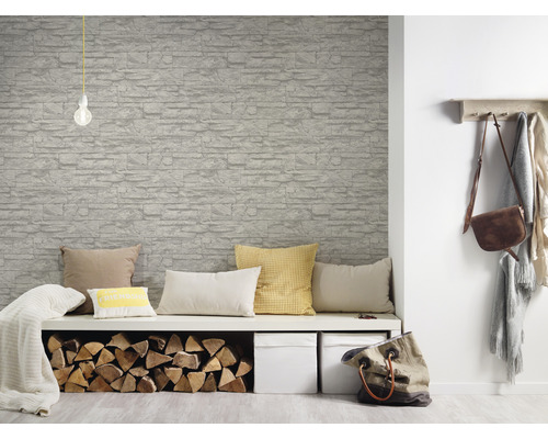 Wohnraum mit Steinoptik Tapete, Sitzbank, Kissen und Holzscheiten