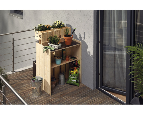 Holz Pflanztisch mit Blumenkästen und Gartenzubehör auf einem Balkon
