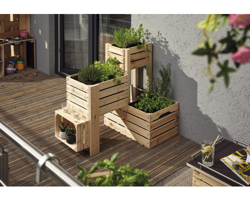 Holzkräuterregal mit Kräutern auf einem Balkon.