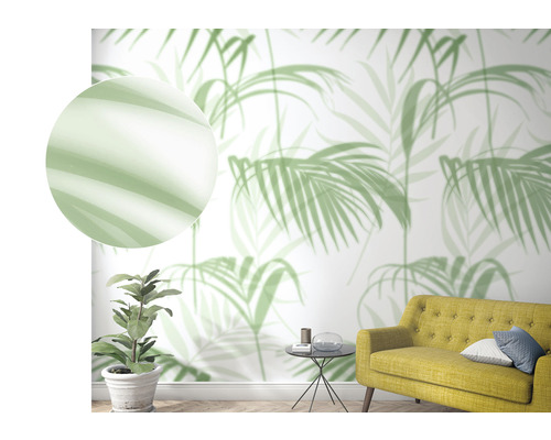 Wohnraum mit Palmenblatt-Tapete, gelbem Sofa und Zimmerpflanze