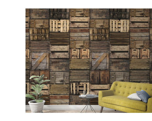 Wohnraum mit einer Tapete im Design von übereinander gestapelten Holzkisten und einem gelben Sofa.