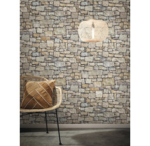 Dekoratives Interieur mit Steintapete, Rattansessel, Kissen und Hängelampe