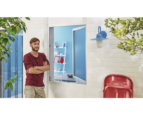 Mann steht vor einem Haus mit Insektenschutzgittertür und Außenleuchte