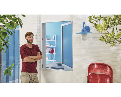 Mann vor Insektenschutz an Tür und Fenster stehend