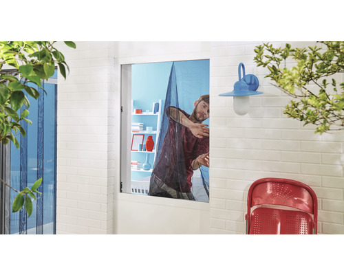 Mann befestigt ein Insektenschutzgitter an einem Fenster.