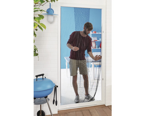 Mann geht durch eine Insektenschutztür, Grill im Vordergrund