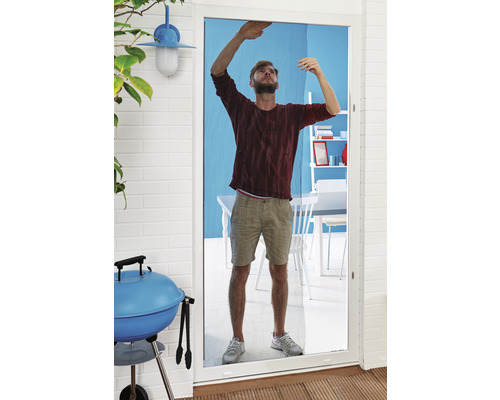 Ein Mann installiert ein Insektenschutzgitter an einer Terrassentür.