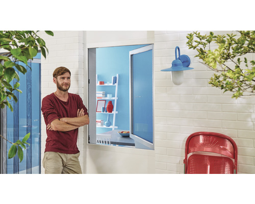 Außenansicht eines Hauses mit Insektenschutzgitter, Fenster, Wandleuchte und Mann