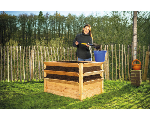 Hochbeet aus Holz mit drei Ebenen und einer Frau, die Erde einfüllt.