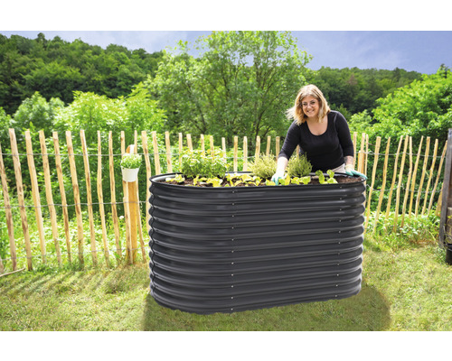 Hochbeet aus Metall im Garten mit gärtnernder Frau