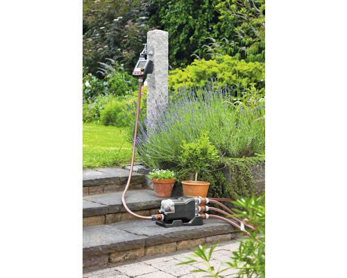 Bewässerungssystem mit Verteiler, Bewässerungscomputer und Gartenschlauch im Außenbereich
