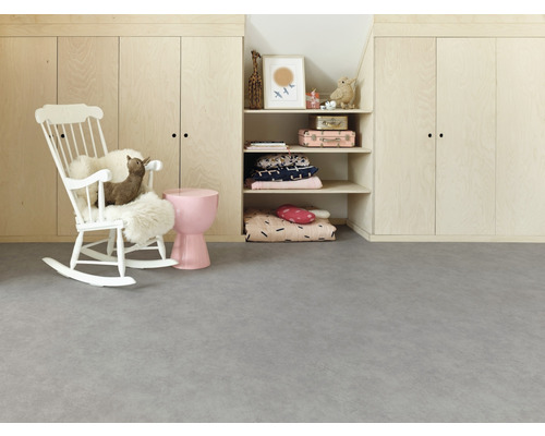 Kinderzimmer mit weißem Schaukelstuhl, rosa Hocker und Regalen