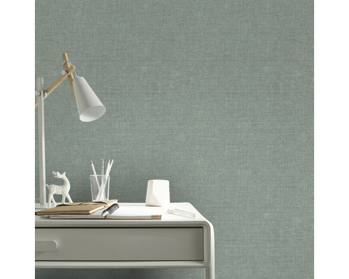 Nahaufnahme eines Arbeitsbereichs mit einer grünen Textiltapete im Hintergrund