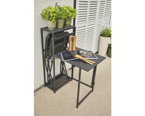 Gartenszene mit Klapptisch, Klappstühlen, Kräutertöpfen, Kochbuch und Küchenutensilien