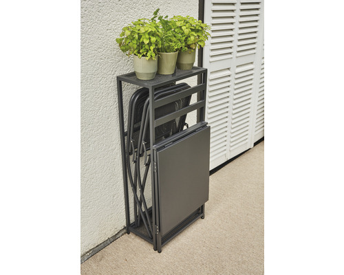 Klapptisch und Klappstühle in einem Regal, dazu Pflanzen