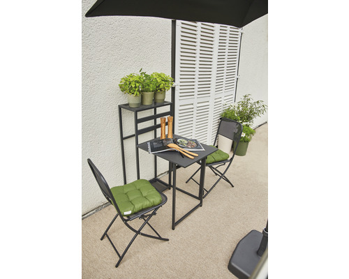 Gartenszene mit Tisch, Stühlen, Pflanzen und Regal vor einer Wand