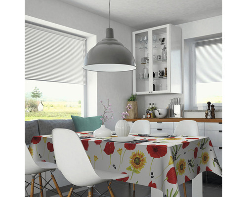 Heller Essbereich mit Esstisch, Stühlen und Tischdecke mit Blumenmuster.