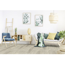 Heller Wohnraum mit Sofa, Sessel, Kommode, Leiter und Dekoration