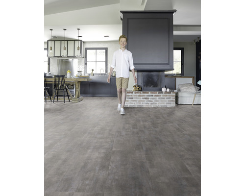 Heller Wohnraum mit Designboden in Holzoptik, Kamin und jungem Mann