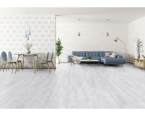 Heller Wohnraum mit Esstisch, Stühlen und Sofa auf hellem Holzboden.