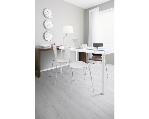 Helles Arbeitszimmer mit Schreibtisch, Stühlen und Wanduhren