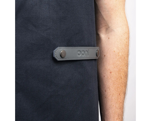 Detail einer Grillschürze mit grauem Lederdetail und Ooni Logo.