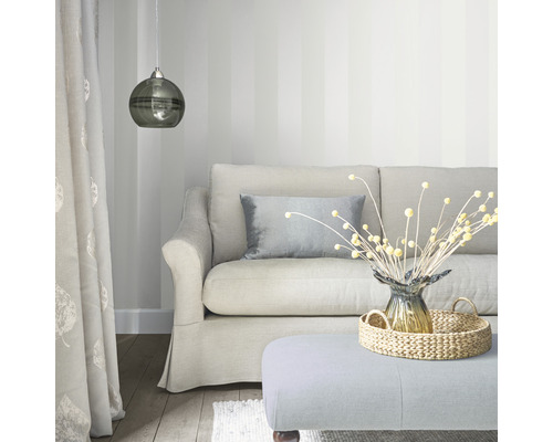 Wohnzimmer mit Sofa, Kissen, Lampe und Dekorationsartikeln