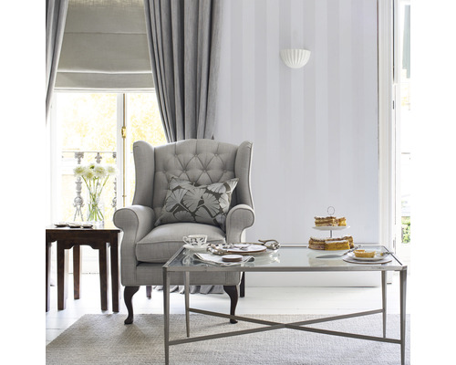 Wohnzimmer mit Sessel, Couchtisch, Vorhängen und Dekor