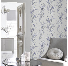 Wohnzimmer mit floral gemusterter Tapete, Sessel und Tisch