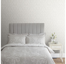 Schlafzimmer mit floral gemusterter Tapete, Bett und Nachttisch