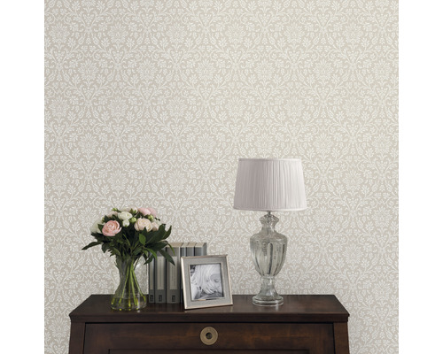 Tapete mit floralem Muster im Interieur mit Tisch, Lampe, Blumen und Bilderrahmen