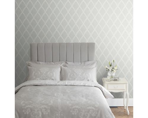 Schlafzimmer mit Bett, Nachttisch und gemusterter Tapete