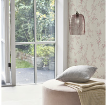 Wohnraum mit floraler Tapete, Pendelleuchte, Kissen und Hocker
