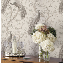 Innenraum mit gemusterter Tapete mit Pfauen, Blumen, Getränke-Set auf einem Tisch und Blumen in Vasen.