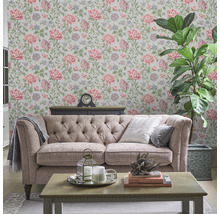 Wohnzimmer mit floral gemusterter Tapete, Sofa und Zimmerpflanze
