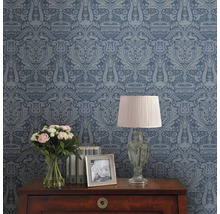 Dekorative Tapete mit Muster auf einer Zimmerwand, Tisch mit Lampe, Blumen und Bilderrahmen