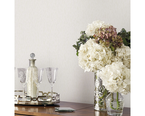 Dekoratives Arrangement mit Blumen, Karaffe und Gläsern auf einem Tisch