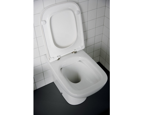 Weisse Standtoilette mit offenem Toilettendeckel vor weissen Fliesen