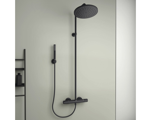 Schwarze Duscharmatur mit Kopf- und Handbrause an der Wand montiert.