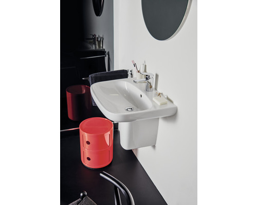 Modernes Badezimmer mit weißem Waschbecken und Ablagefläche, rotem Schrank und schwarzem Boden