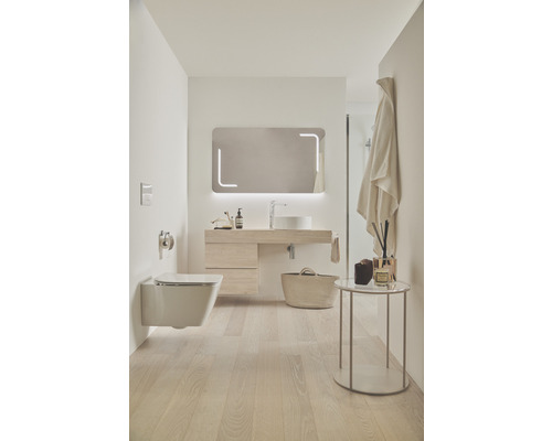 Helles Badezimmer mit Toilette, Waschtisch, Spiegel und Accessoires