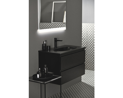 Badezimmer mit schwarzem Waschtischunterschrank, Aufsatzwaschbecken und beleuchtetem Spiegel