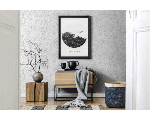 Wohnraum mit Blumentapete, Holzkommode, Bild und Dekoration