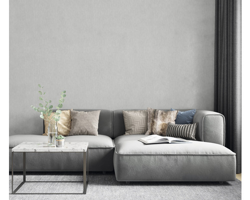 Wohnzimmer-Szene mit grauem Ecksofa, Kissen, Beistelltisch und Dekoration