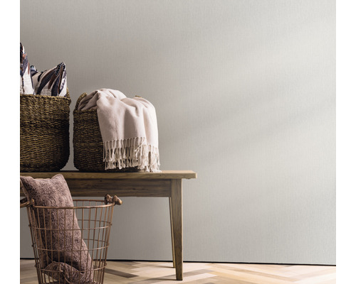 Dekorative Szene mit Körben und Textilien auf einem Holztisch vor einer Wand