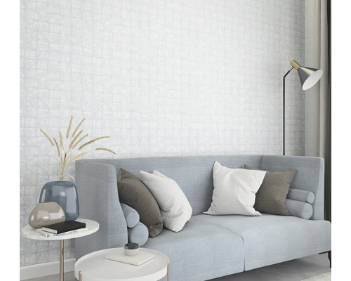 Helles Wohnzimmer mit Sofa, Kissen, Beistelltischen und gemusterter Tapete