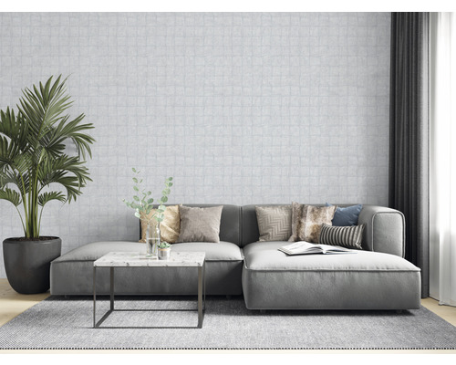 Wohnzimmer mit Sofa, Kissen, Tisch, Zimmerpflanze und gemusterter Tapete