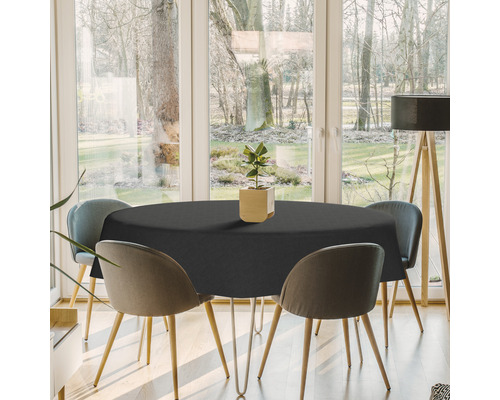 Esstisch mit runder, schwarzer Tischdecke in einem hellen Esszimmer