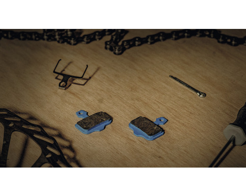 Fahrradbremsbeläge und Fahrradteile auf einer Holzoberfläche