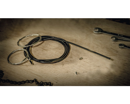 Fahrrad Schaltzug und Bremszug Set mit Werkzeug auf einer Holzoberfläche